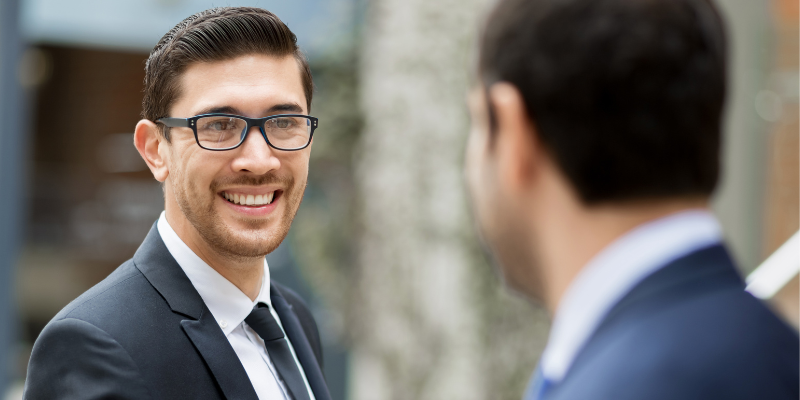 a business man smiling at another man